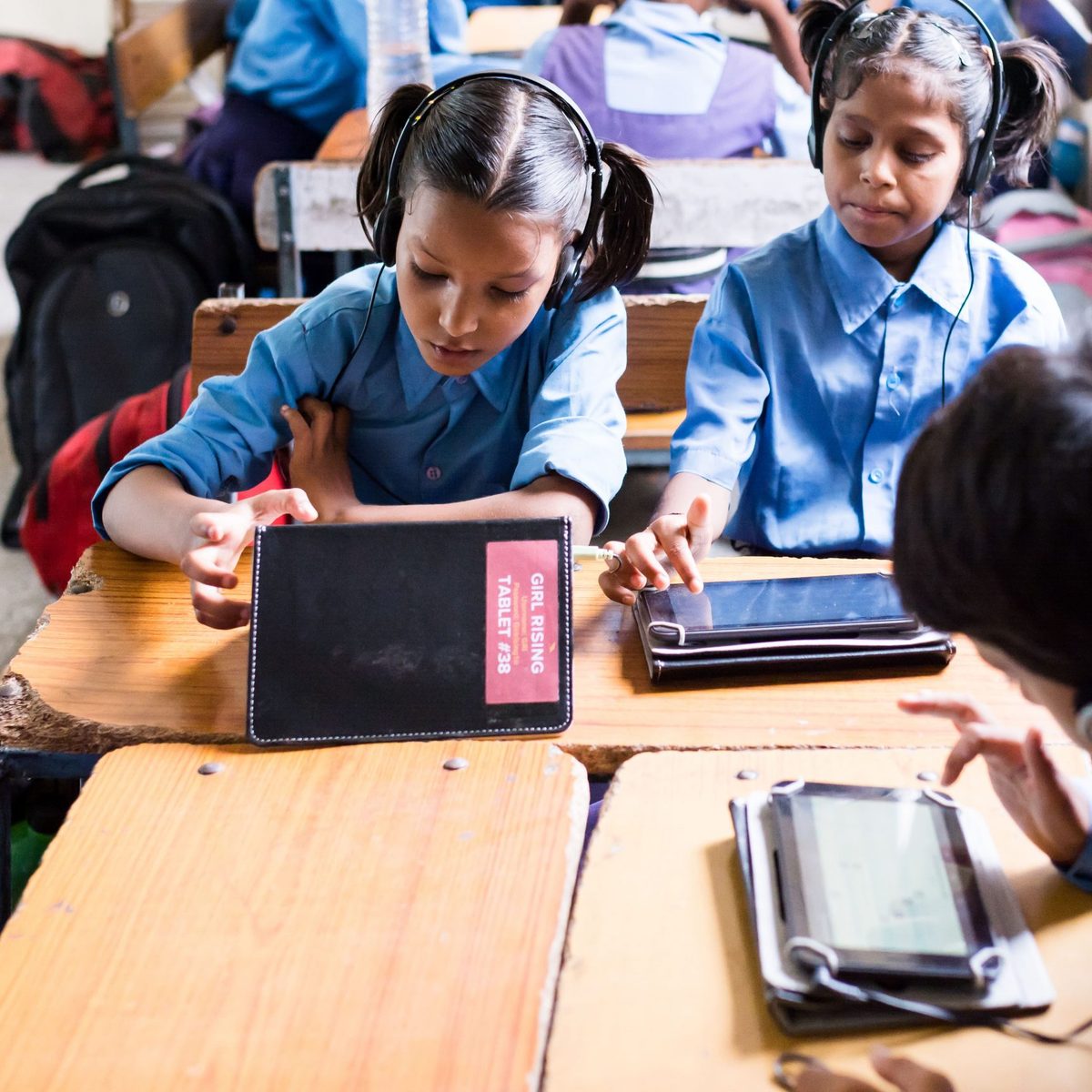 Girls in a Girl Rising classroom programme working on tablets with headphones